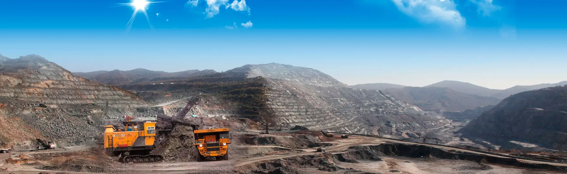 Haul trucks working a bench in an open pit mine