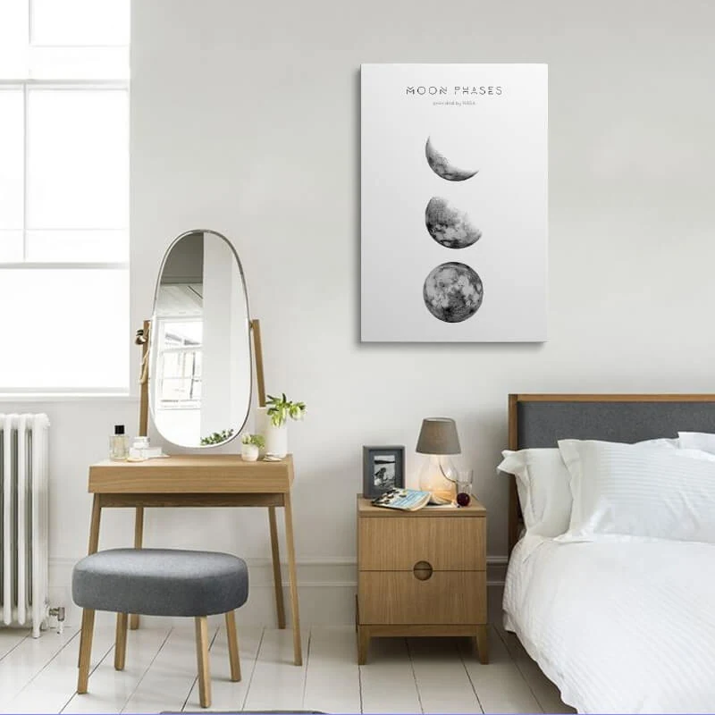 Moon Phases Picture canvas hung in a bedroom above a bedside table
