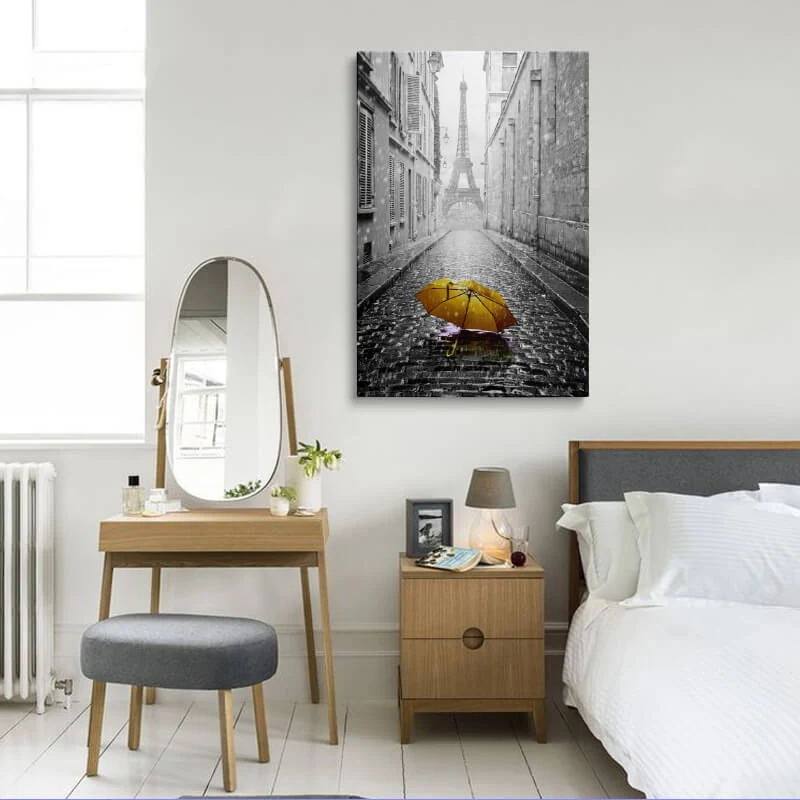 Orange Umbrella Eiffel Tower canvas hung in a bedroom above a bedside table