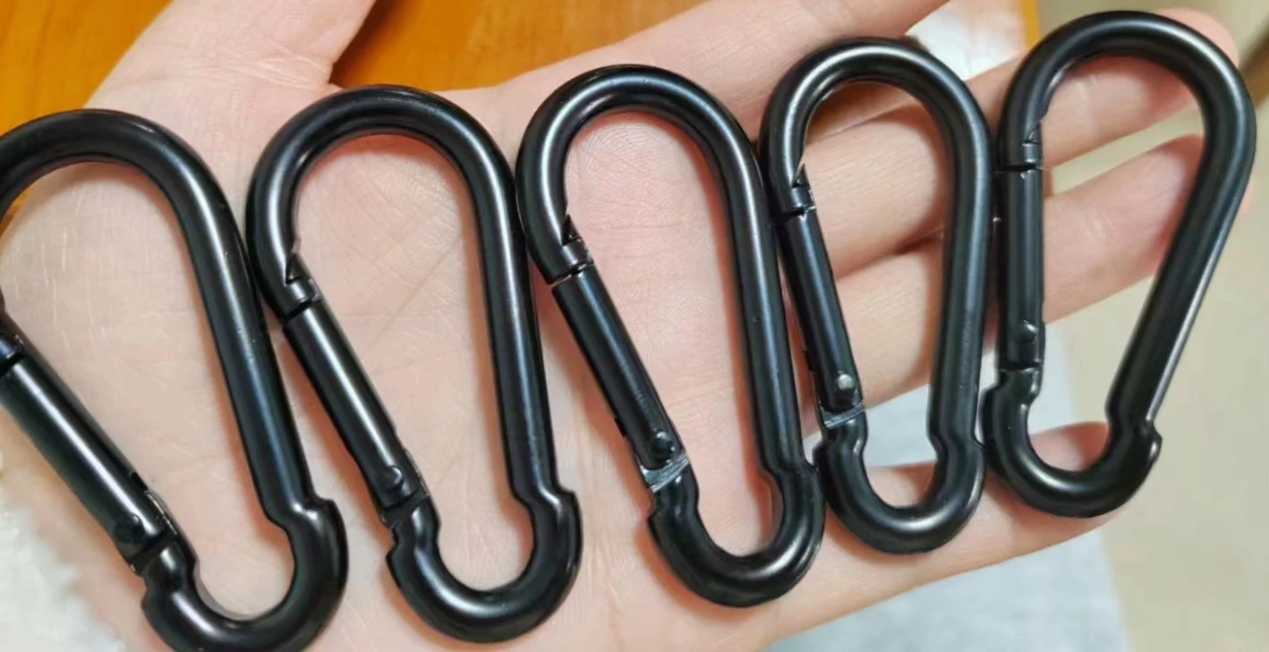 Five black metal snap-hook carabiners held f