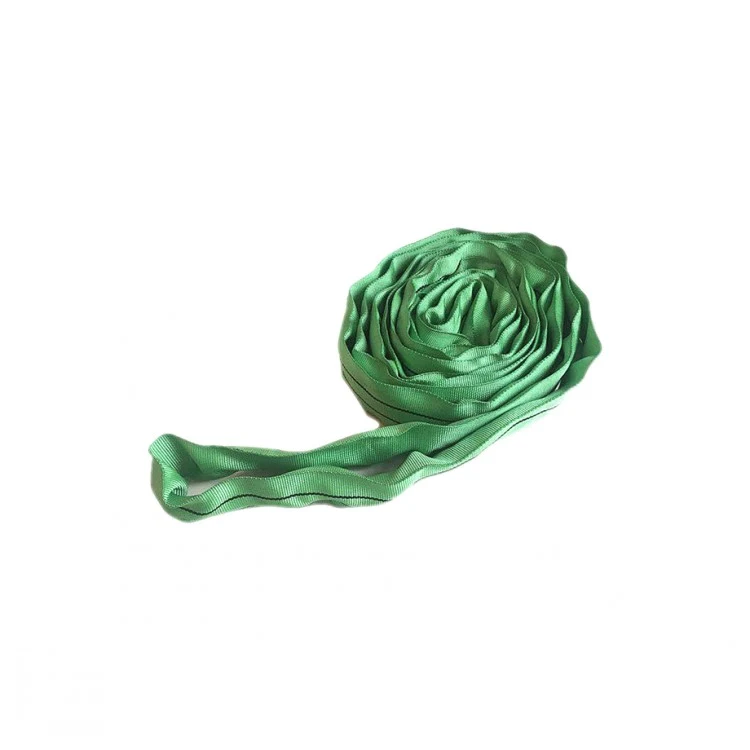 Coiled green polyester webbing sling with stitched loops lying on a plain white background