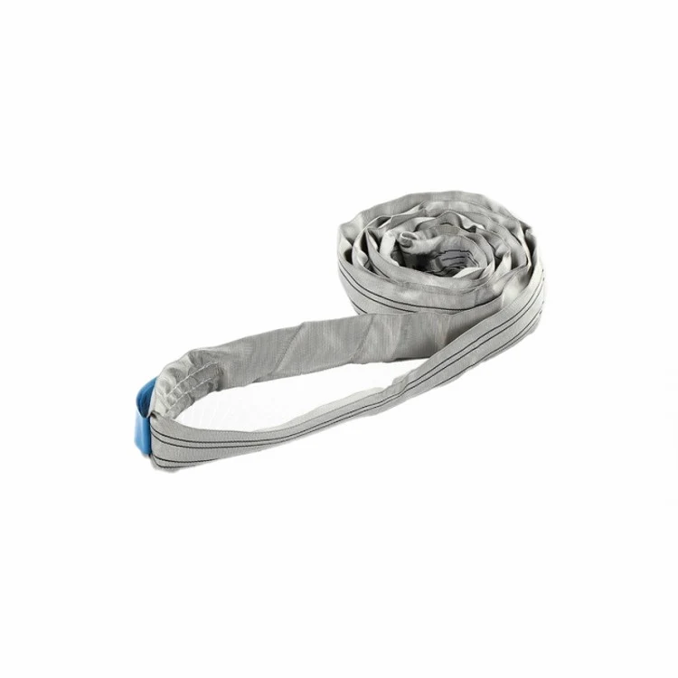 Coiled gray round lifting sling with blue protective ends on a plain white background