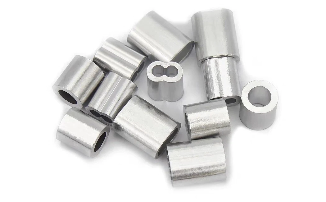 Group of aluminum swage sleeve ferrules with figure-eight bores on a white background
