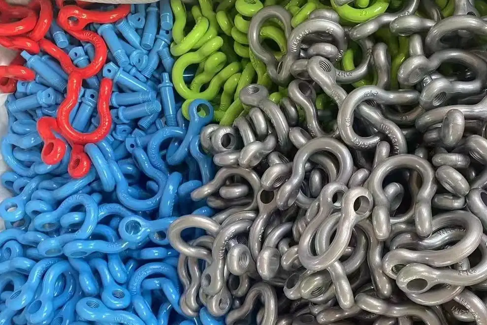 Bulk piles of red, blue, green, and galvanized steel lifting bow shackles grouped by color