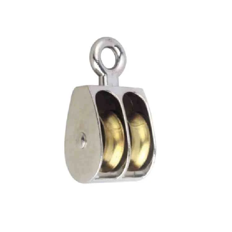 Polished metal double-sheave pulley block with fixed eye and brass wheels, isolated on white background