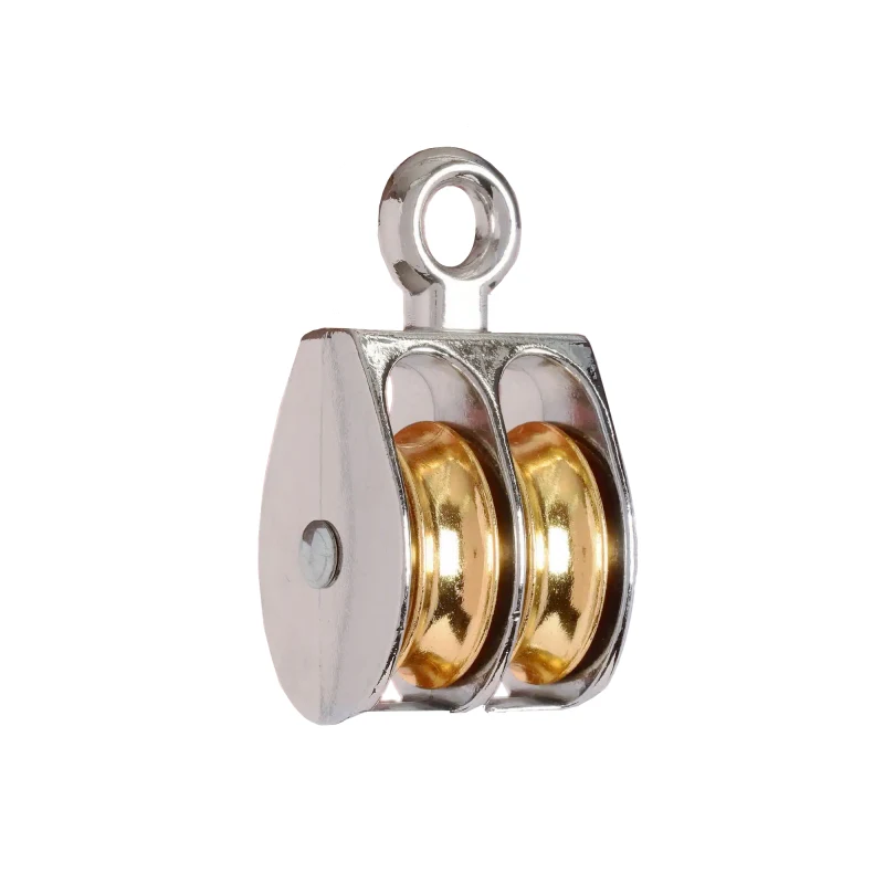 Double-sheave pulley block with polished metal housing, brass wheels, and top eye ring on white background