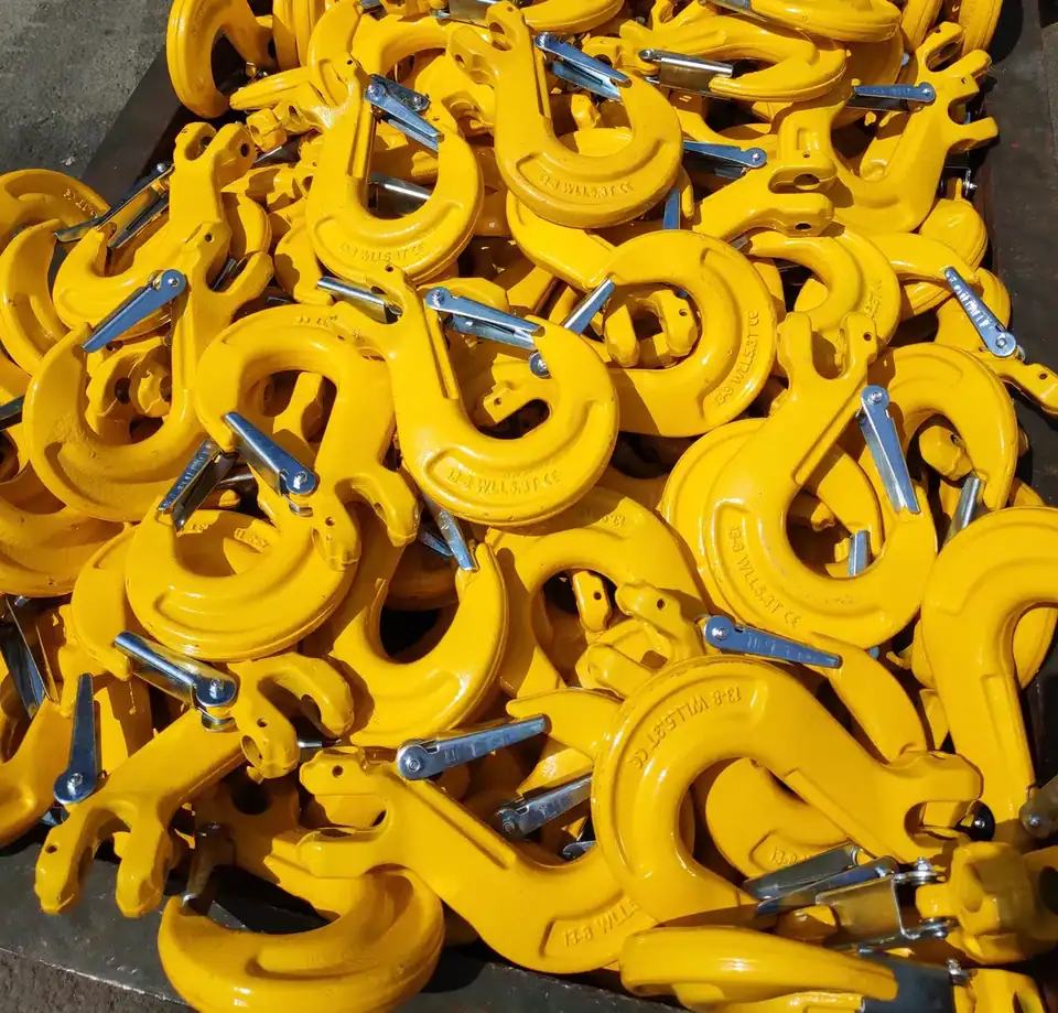 A large pile of yellow rigling hooks with silver safety latches