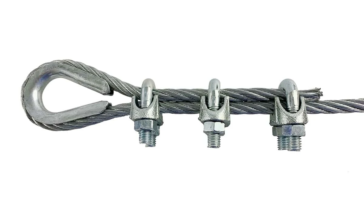 Steel wire rope with thimble eye loop secured by three wire rope clips on a white background