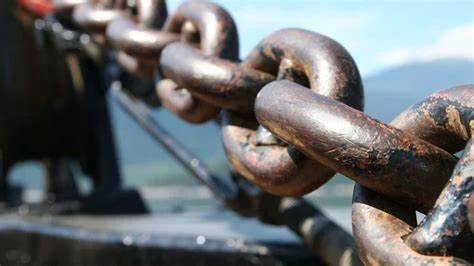 Close-up of a heavy, rusty industrial metal chain link