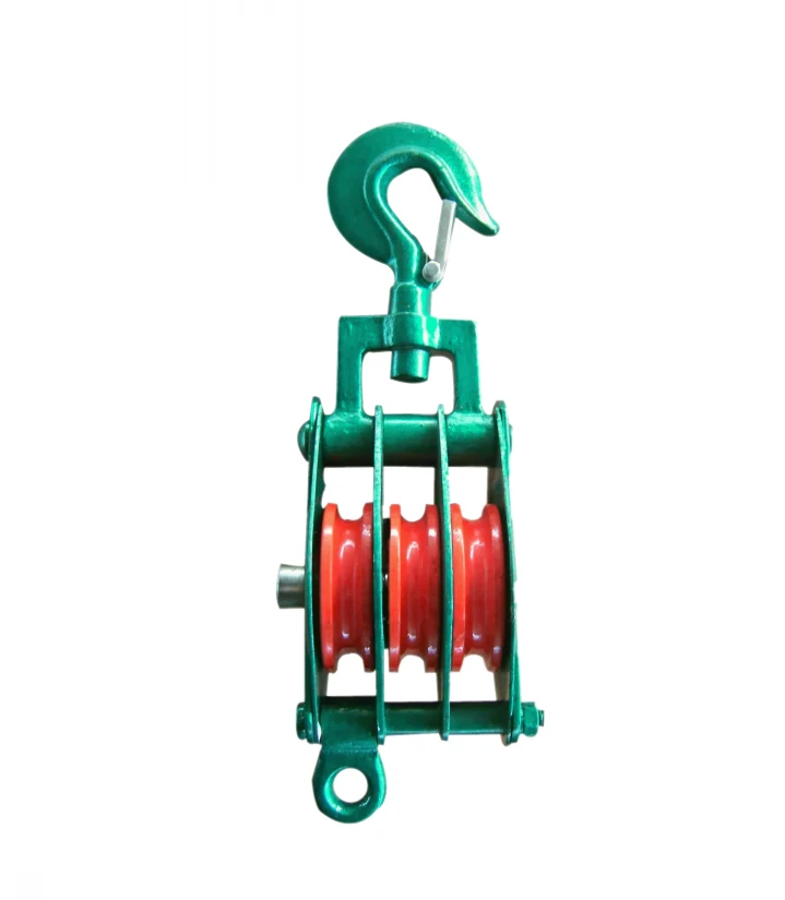 Green triple-sheave pulley block with swivel hook, red wheels and lower eye ring on white background