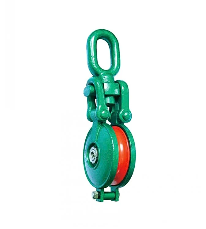 Green industrial pulley block with orange sheave and top eye loop on white background