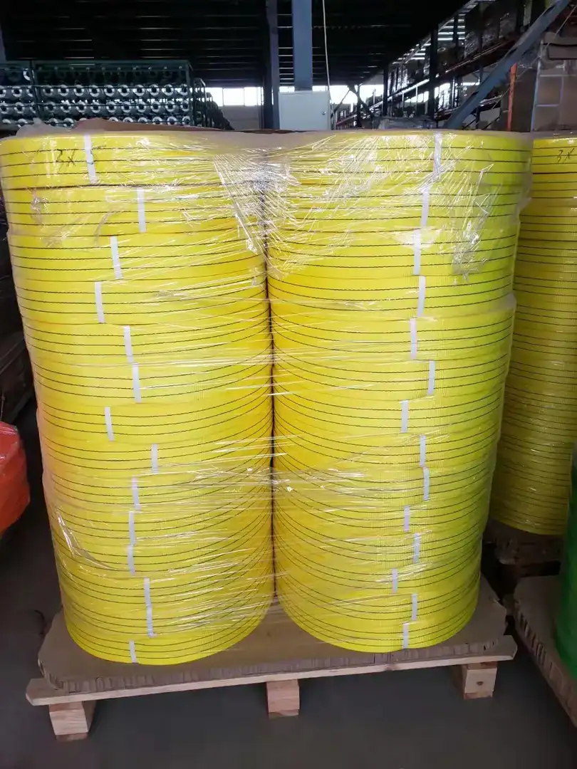 Pallets of yellow coiled webbing wrapped in clear plastic in a warehouse