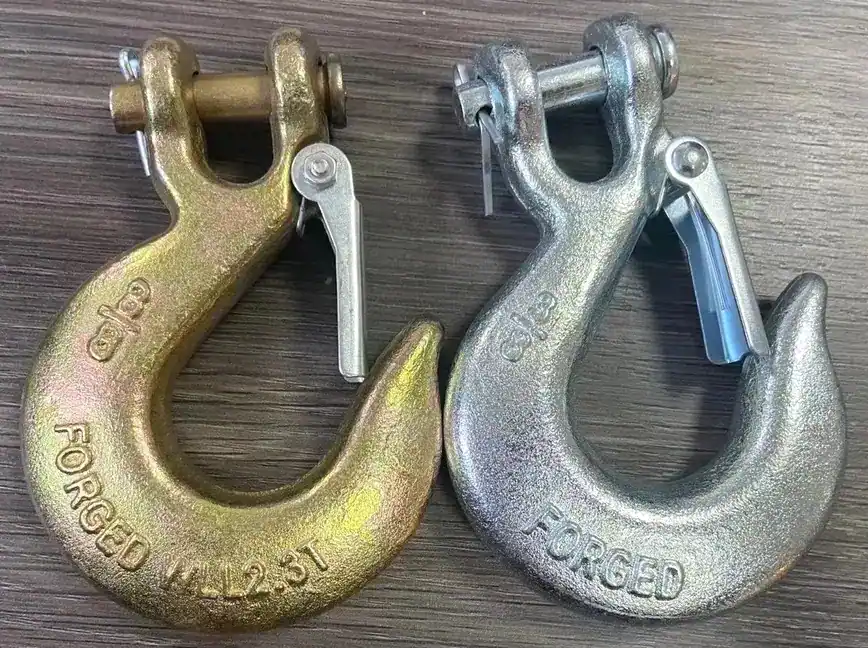 Two chain-hook-types, one gold and one silver, on a wooden surface