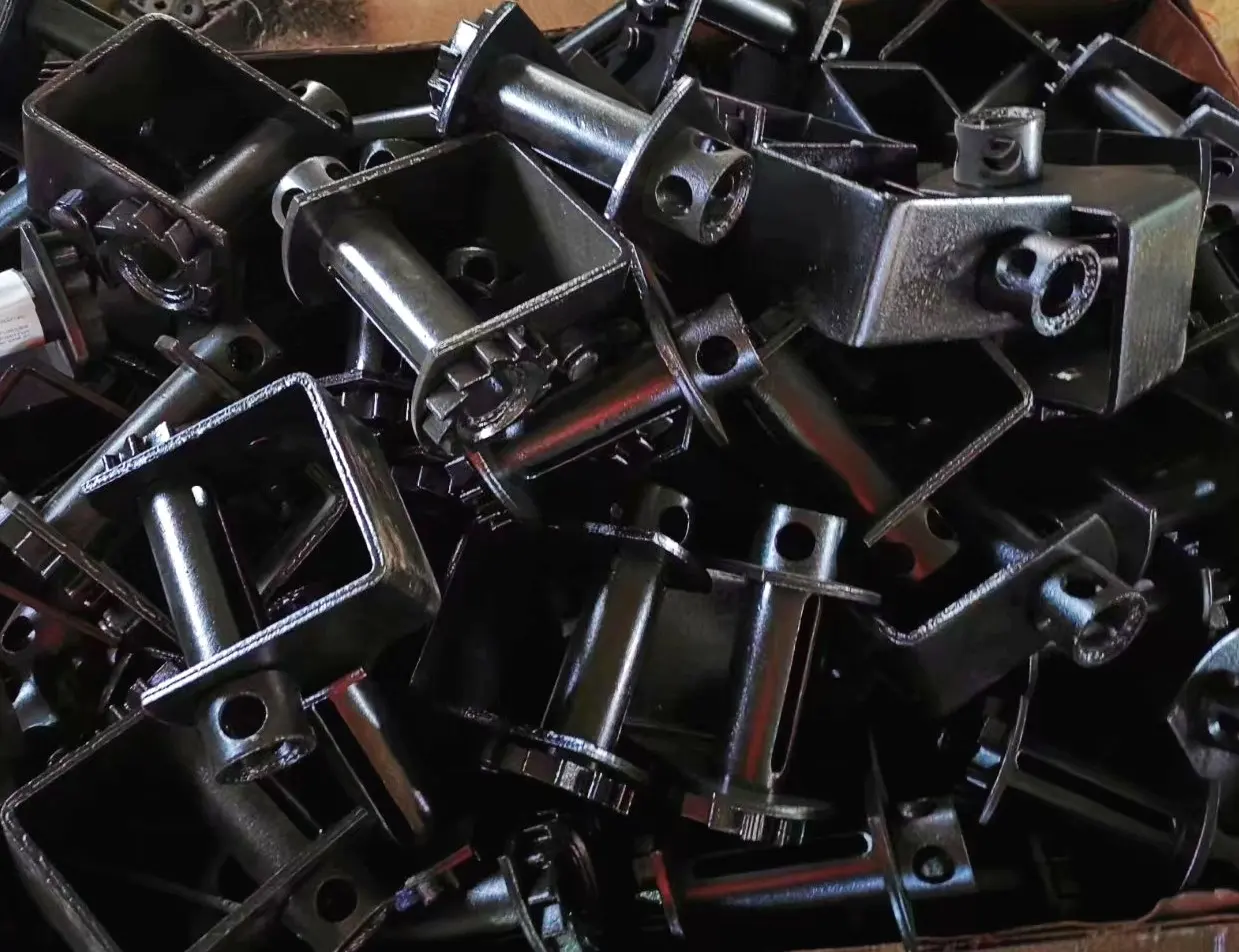 Pile of black steel winch mounting brackets with cylindrical housings and square plates