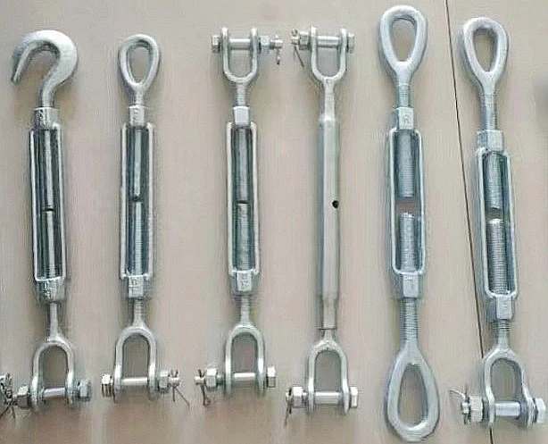 Six galvanized steel turnbuckles with hook, eye, and jaw end fittings arranged in a row on a light surface