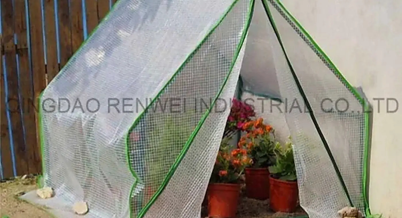 Walk-in greenhouse frame with a leno cover in a garden