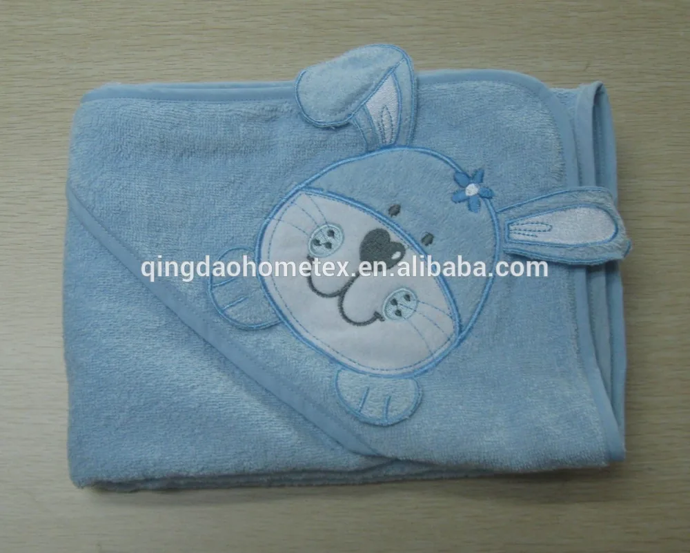 Light blue hooded baby towel with embroidered rabbit appliqué, folded on a plain surface