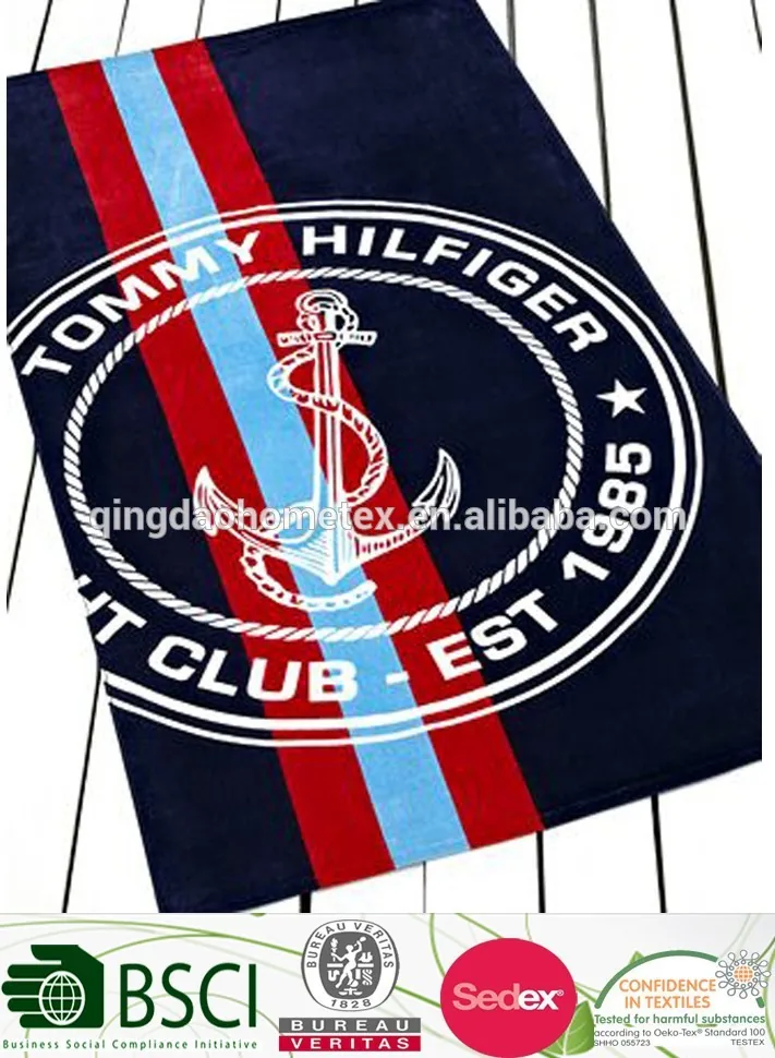 Navy striped beach towel with white anchor emblem; certification logos overlaid at bottom