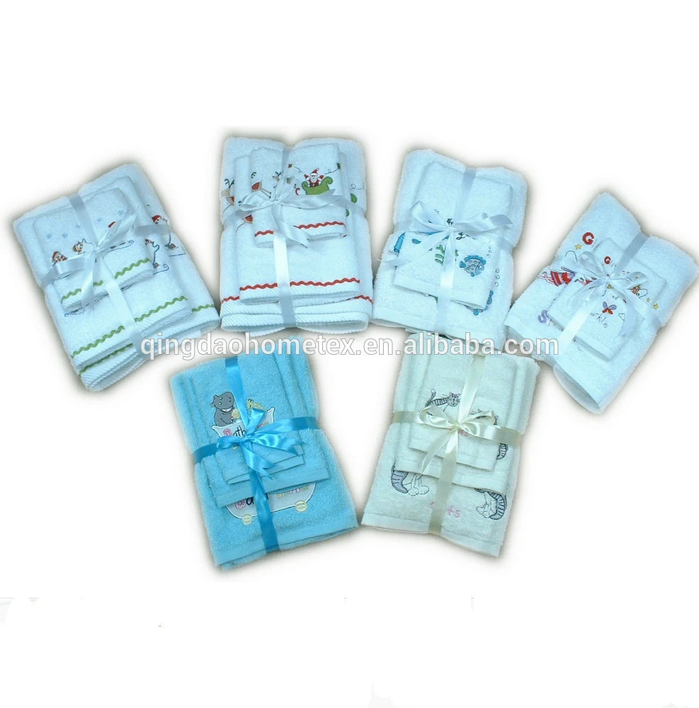 White 100% cotton towel set with embroidered motif and ribbon trim, 70x140 cm, showing the dobby border and stitched detail