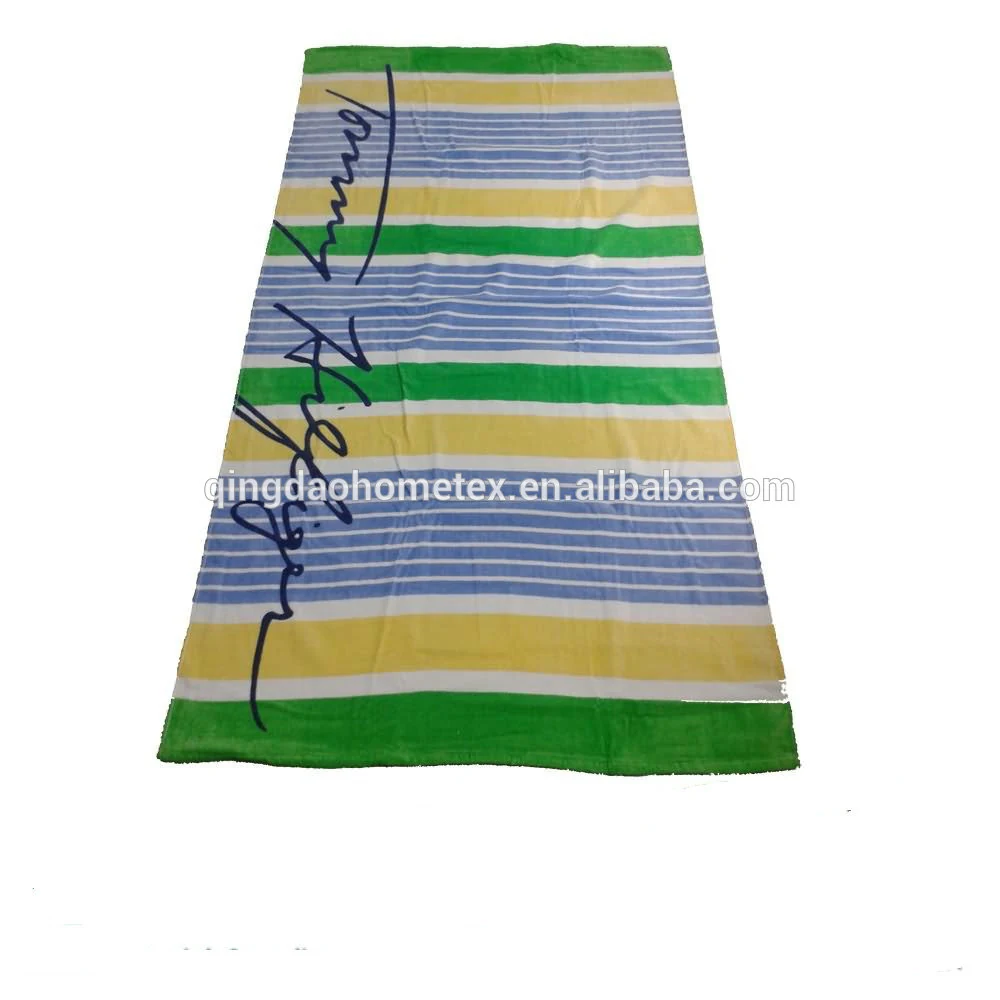 Striped towel in green, yellow, blue, and white with a signature design, laid flat on a white background.