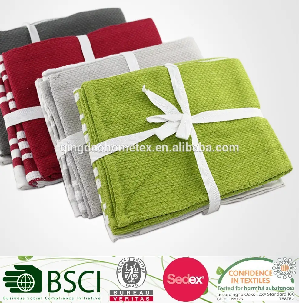 Folded cotton kitchen towels in grey, red, striped and green tied with white ribbons, certification logos banner below