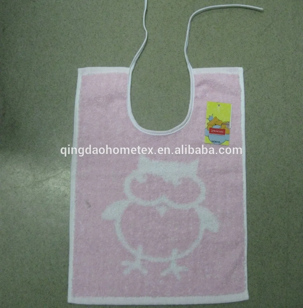 Pink woven baby bib with white chick design, tie strings, and yellow hang tag on plain floor