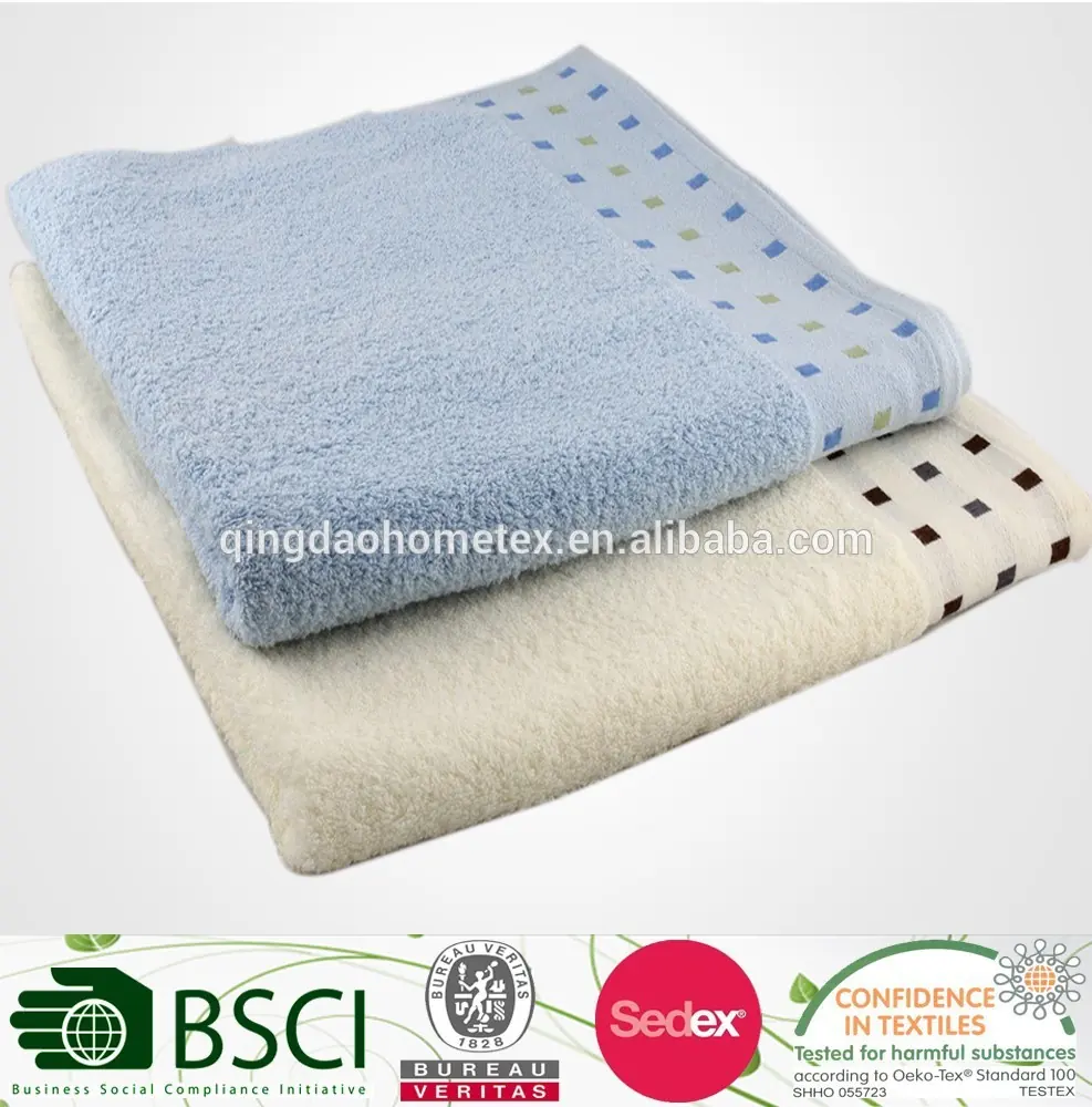 Stack of folded light blue and cream towels with dotted borders on a plain white background