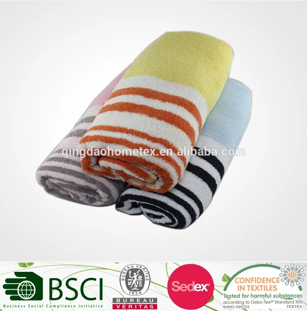 Three rolled striped towels in yellow-orange, gray, and white with black, above a strip of certification logos