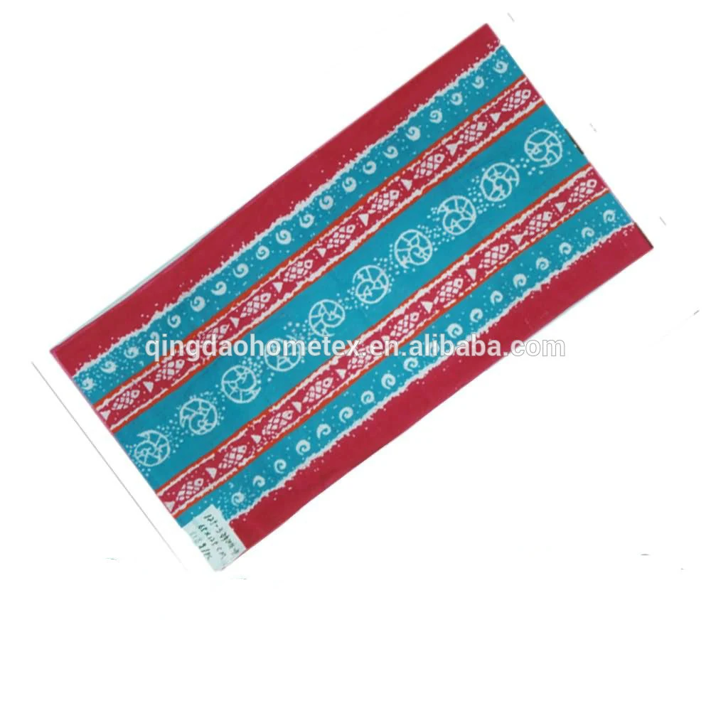 Red and teal batik-style printed towel or fabric with white circular and wave motifs, diagonal on white background