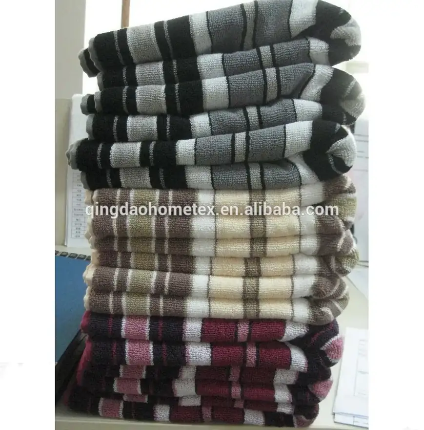 Stack of folded striped towels in gray, beige, and burgundy colors piled on a shelf