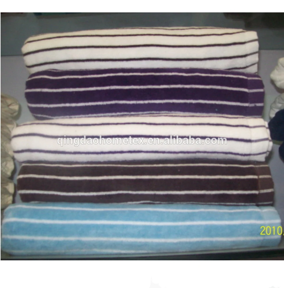 Stack of folded striped towels in white, purple, brown, and blue.