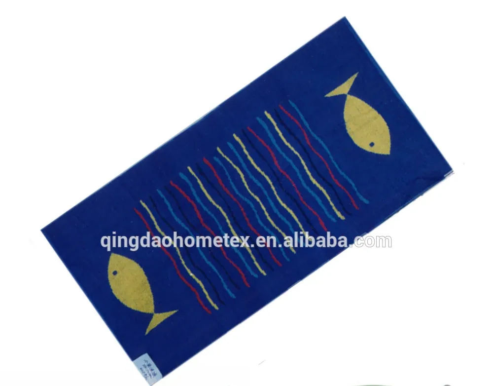 Blue woven towel with yellow fish motifs and multicolored striped waves shown diagonally on white background