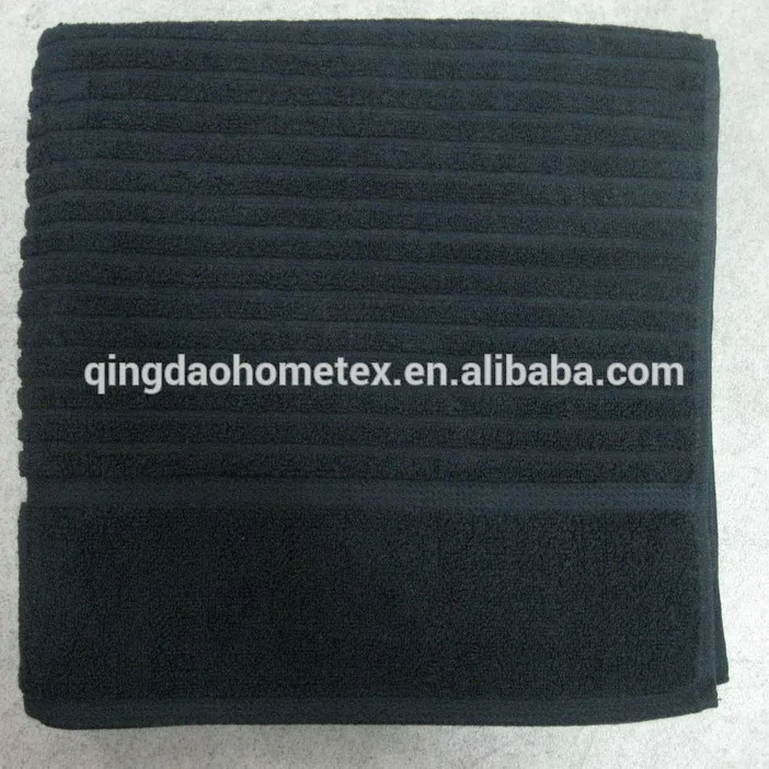 Folded black towel with ribbed texture on a light background