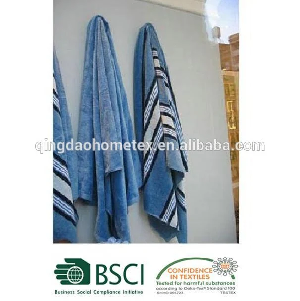 Blue striped beach towels hanging over a balcony rail