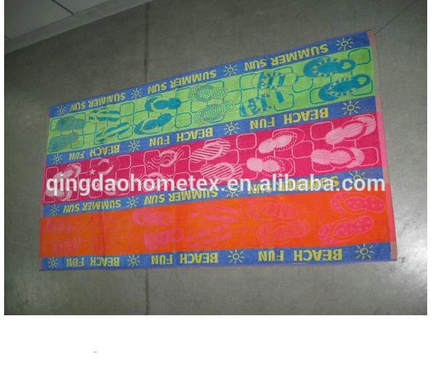 Colorful printed beach towels with 'SUMMER SUN' and 'BEACH FUN' designs laid on a tiled floor