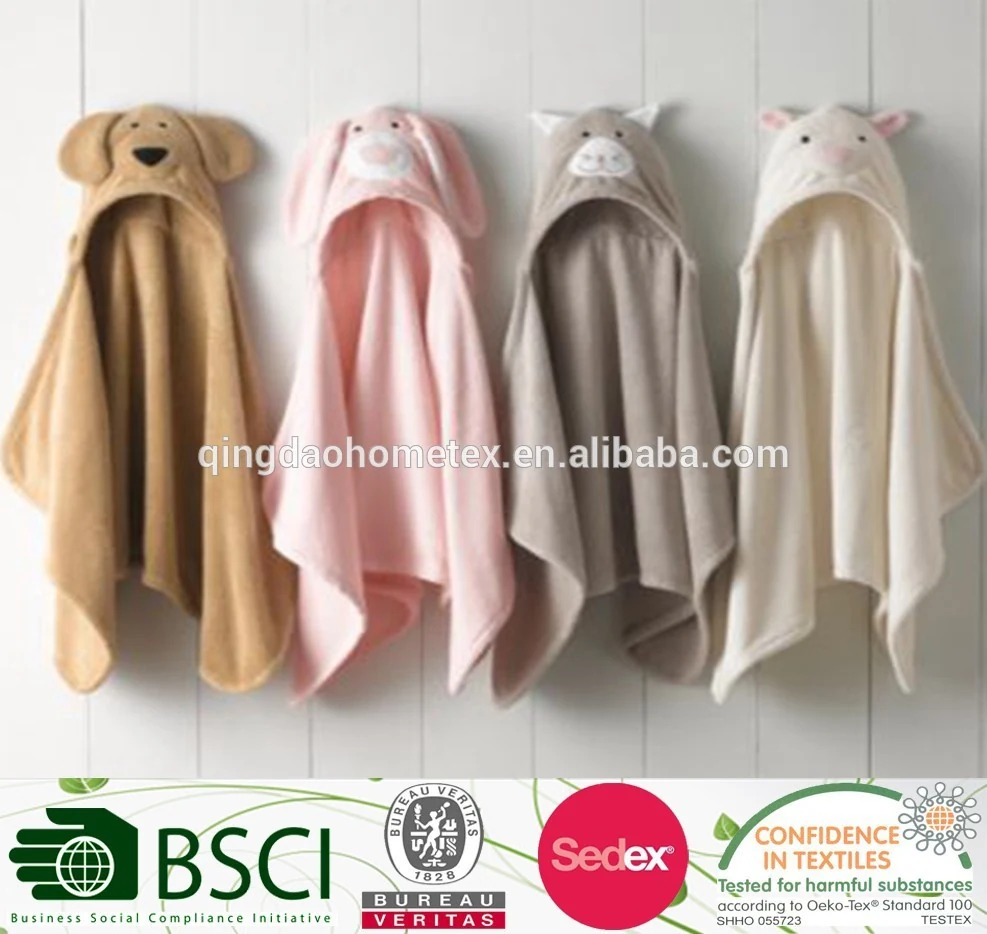 Four hooded animal-themed baby towels in brown, pink, gray and cream hanging on a white wall