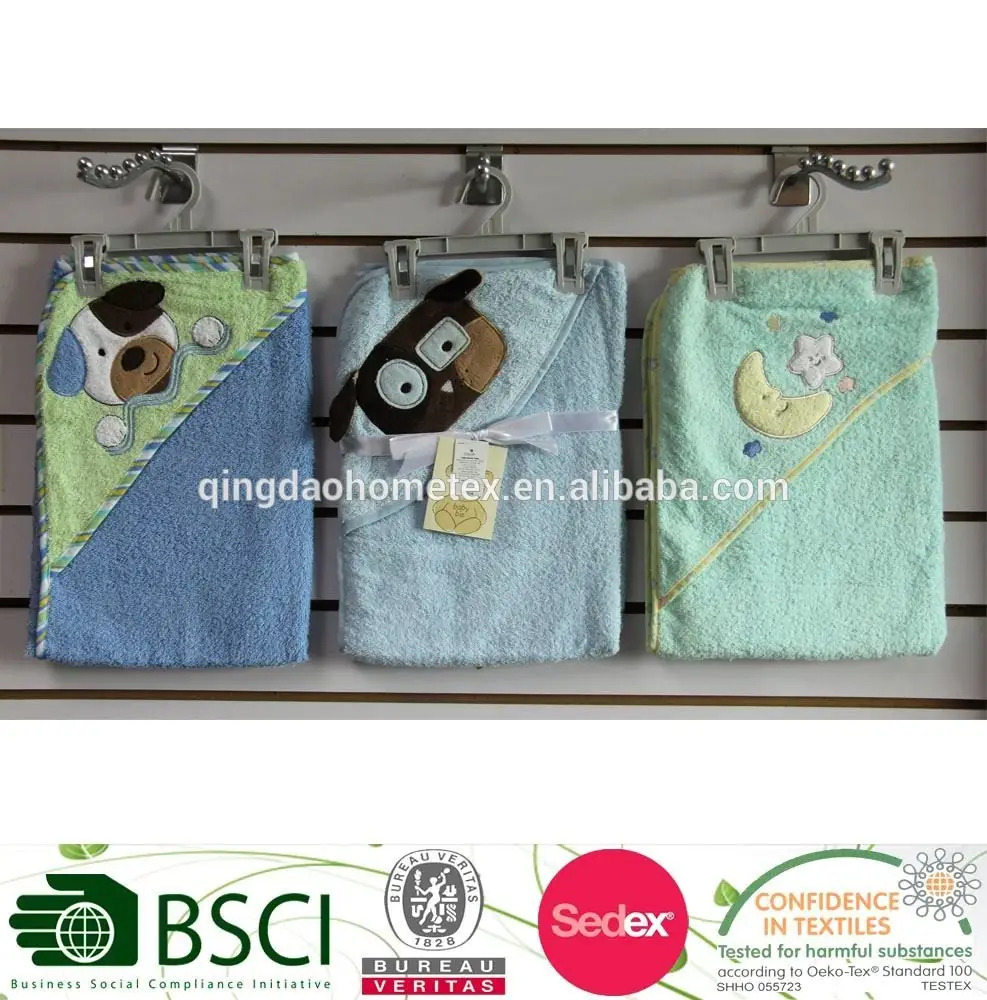 Three hooded baby towels in green and blue with animal appliques hanging on wall hooks