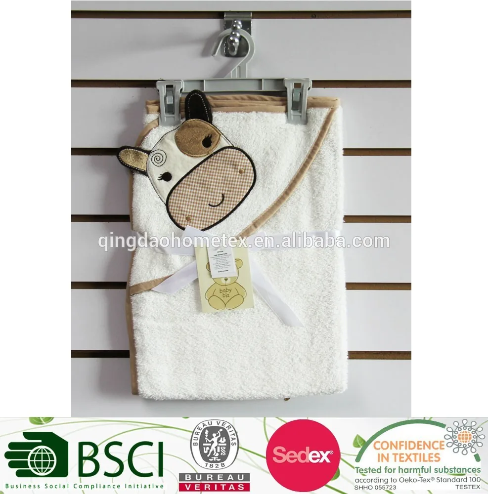 White hooded baby towel with cartoon animal hood hanging on a slatwall hook, with certification logos below