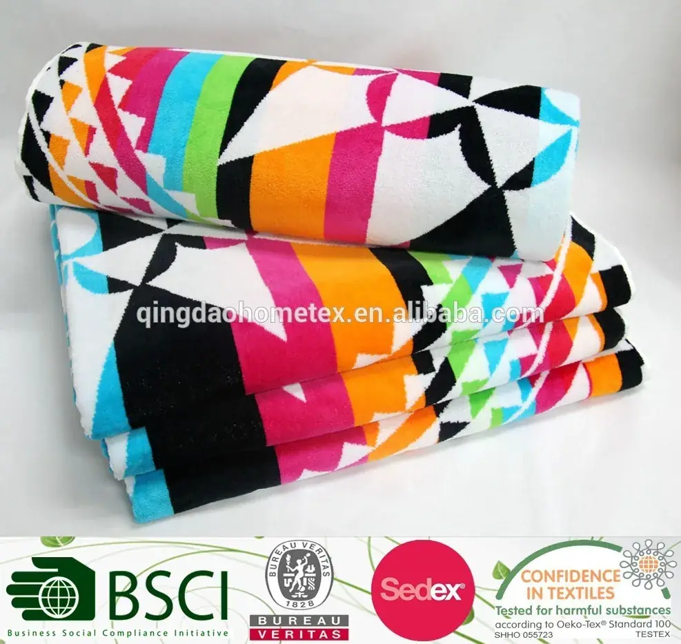 Stack of colorful geometric-patterned beach towels with certification logos banner below
