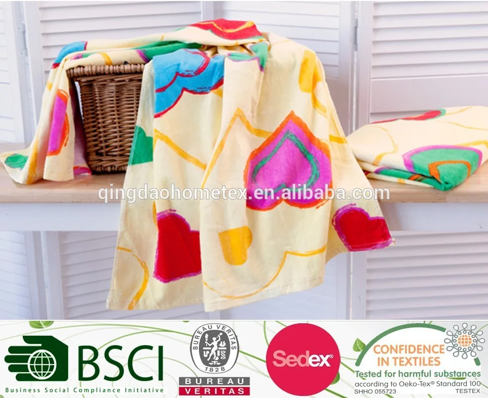 Colorful printed towels draped over a wicker basket on a white wooden bench