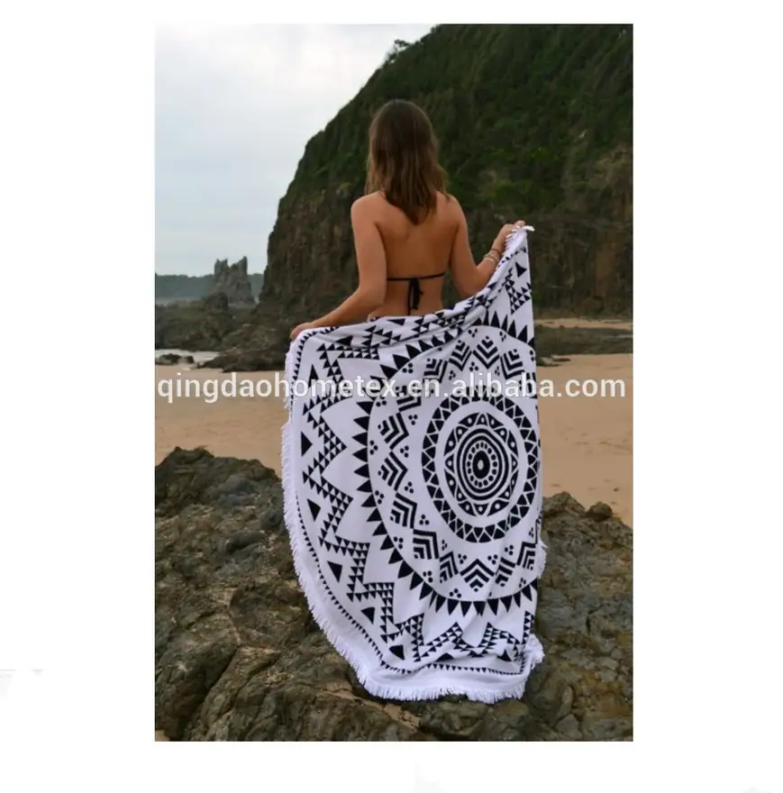 Woman at the beach holding a white round mandarin-patterned fringe beach towel