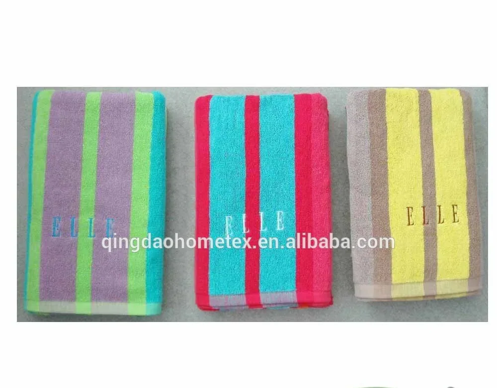 Three striped terry towels in purple-green, pink-turquoise, and yellow-brown with embroidered text, shown with certification logos