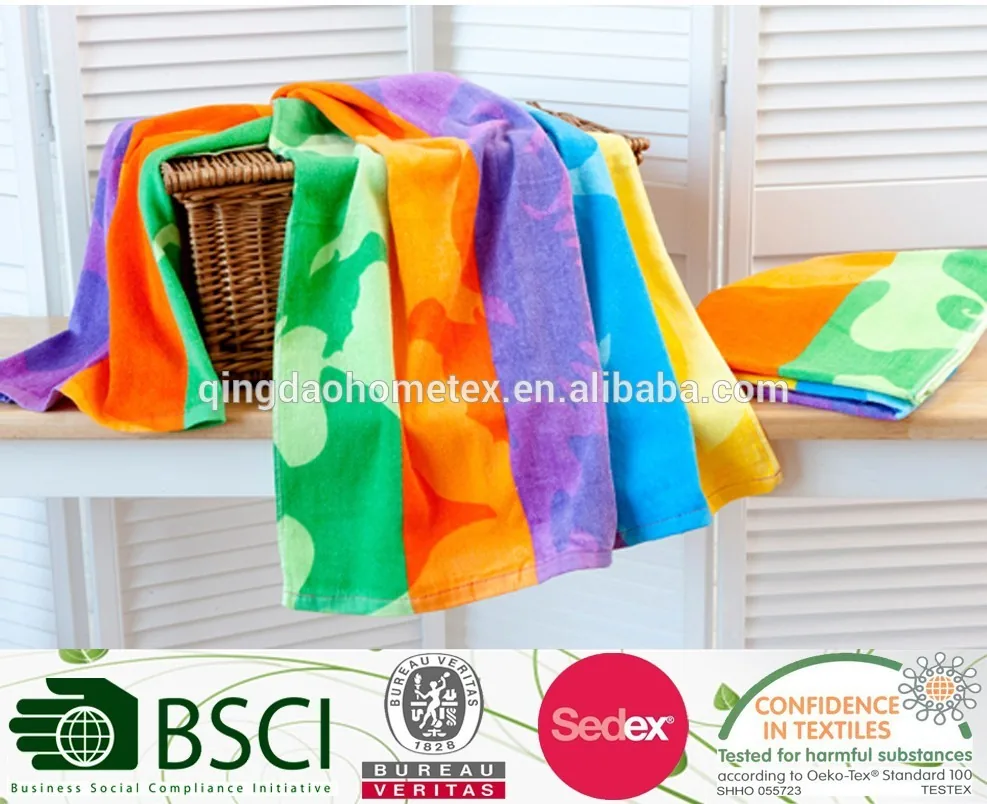 Colorful beach towels draped over a wicker basket with certification logos along the bottom