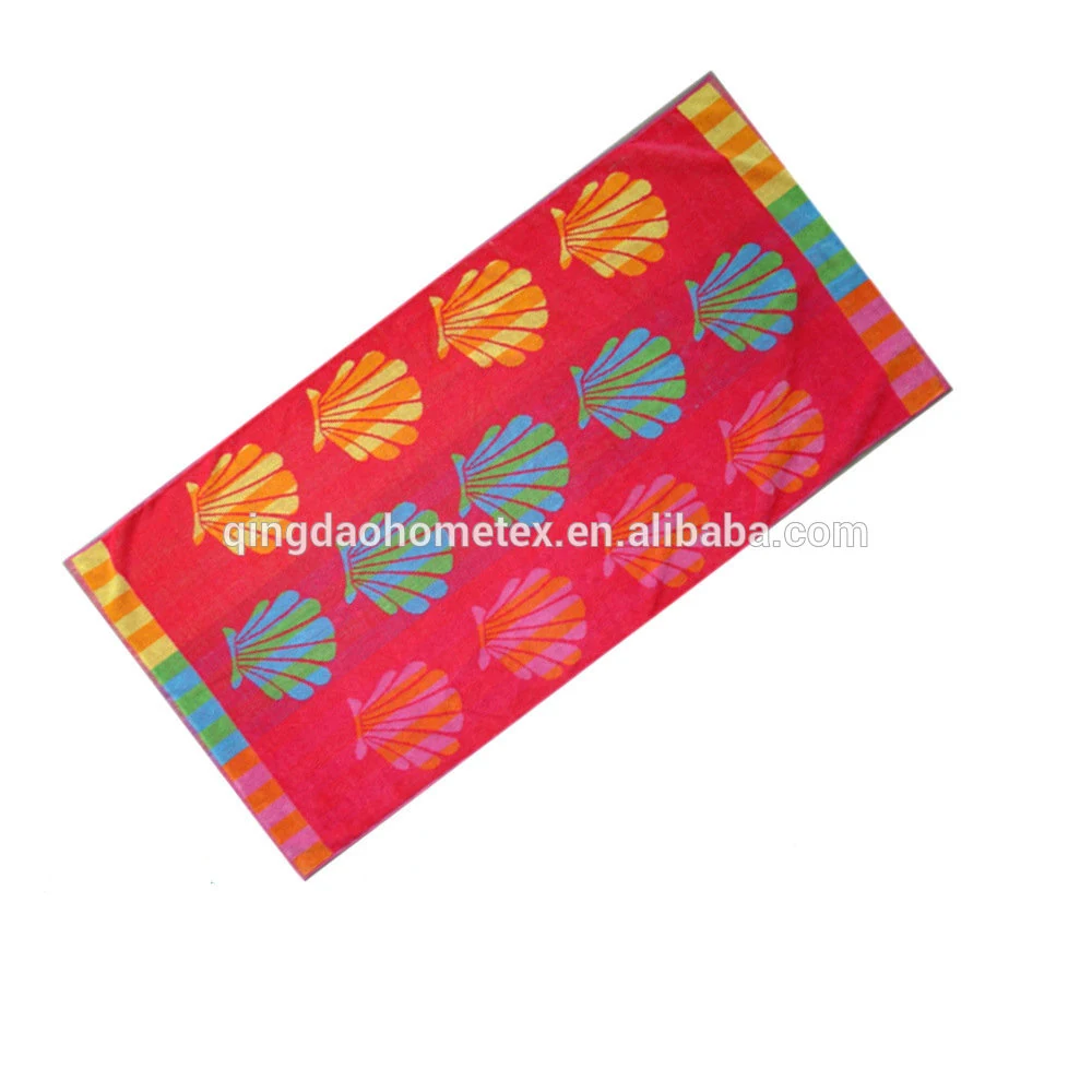 Red beach towel with colorful seashell prints and multicolored striped borders on a white background