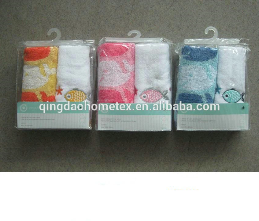 Three packaged sets of printed towels in yellow, pink, and blue with fish designs on retail hangers