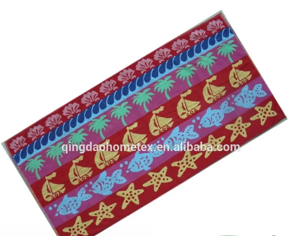 Colorful printed beach towel with palm tree, sailboat, fish and starfish patterns, rotated diagonally with certification logos below
