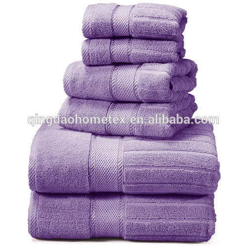 Stack of six folded purple terry cotton towels in assorted sizes on a white background