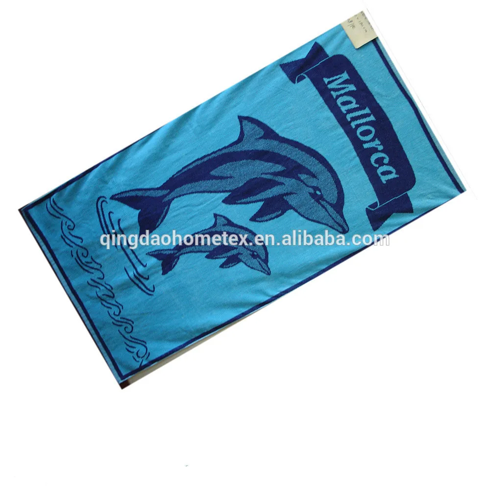 Blue jacquard beach towel with dolphin design and 'Mallorca' banner, shown diagonally on white background