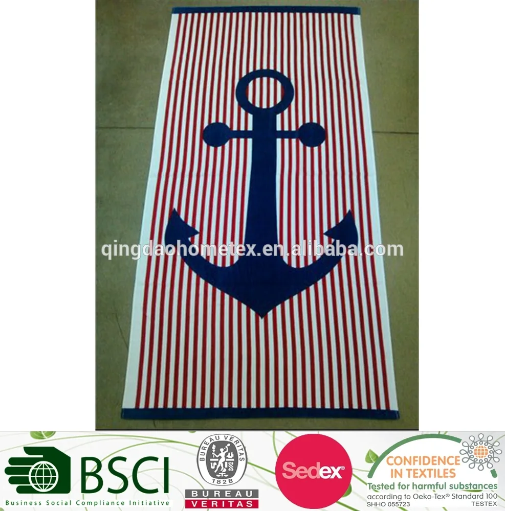 Red and white striped towel with a large navy anchor design, photographed flat on a floor