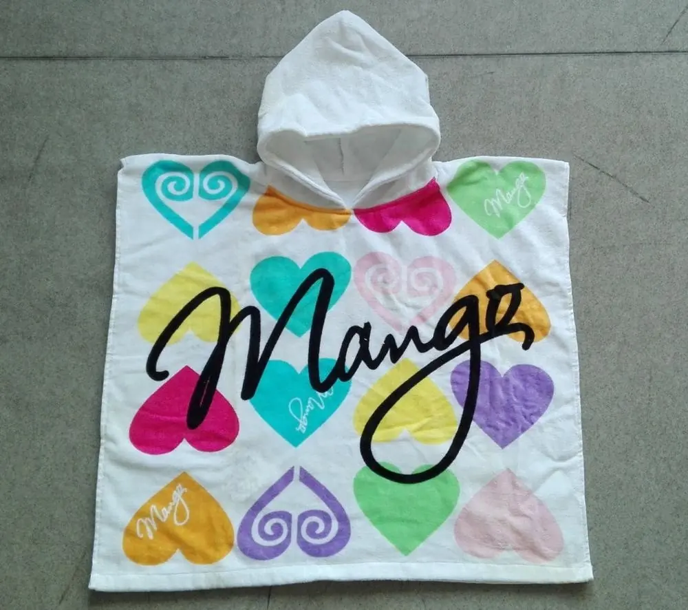 White hooded kids poncho towel printed with colorful hearts and cursive text, laid flat on gray tile